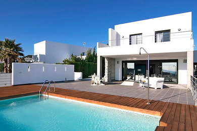 Foto de casa de la piscina y piscina alargada mediterránea de tamaño medio rectangular en patio delantero con entablado