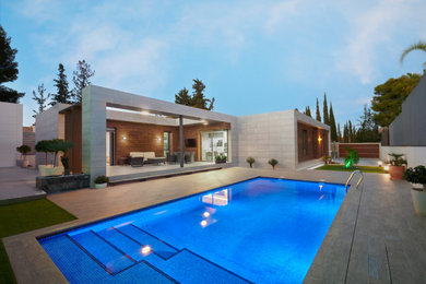 Ejemplo de piscina contemporánea rectangular con suelo de baldosas