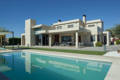 Modelo de casa de la piscina y piscina alargada actual de tamaño medio rectangular en patio delantero con adoquines de piedra natural