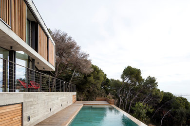 Imagen de casa de la piscina y piscina elevada moderna grande rectangular en patio delantero con entablado
