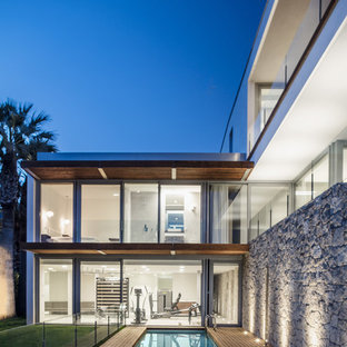 Foto de piscina alargada, moderna, rectangular, en patio trasero, con entablado