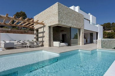 Foto de piscina infinita mediterránea a medida en patio trasero con suelo de baldosas