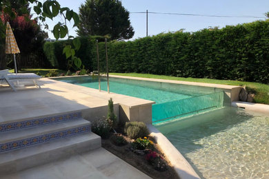 Ejemplo de casa de la piscina y piscina infinita moderna grande rectangular en patio delantero con suelo de baldosas