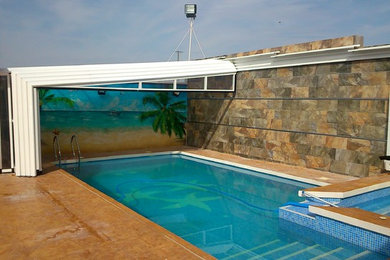 Modelo de casa de la piscina y piscina elevada mediterránea de tamaño medio rectangular en patio delantero con suelo de baldosas