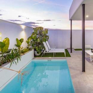 Foto de piscina actual, rectangular, con suelo de baldosas