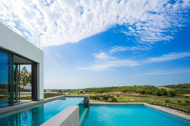 Modelo de casa de la piscina y piscina alargada mediterránea grande rectangular en patio lateral