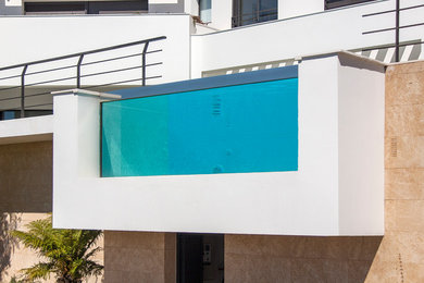 Modelo de casa de la piscina y piscina alargada mediterránea de tamaño medio a medida en patio delantero