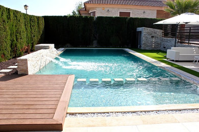 Exempel på en mellanstor modern anpassad pool på baksidan av huset, med en fontän