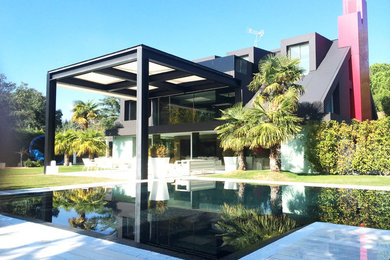 Diseño de casa de la piscina y piscina infinita moderna grande en forma de L