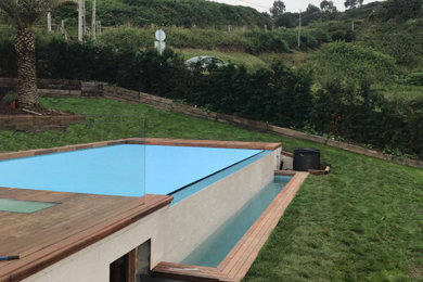 Imagen de casa de la piscina y piscina infinita costera de tamaño medio rectangular en patio lateral con entablado