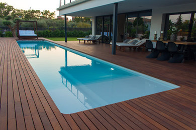 Imagen de casa de la piscina y piscina alargada mediterránea de tamaño medio rectangular con entablado