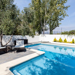 Foto de piscina actual, en forma de L, en patio trasero, con suelo de baldosas