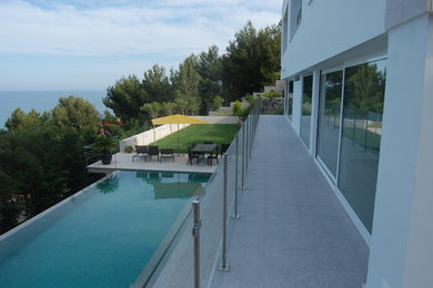 Modelo de casa de la piscina y piscina infinita contemporánea de tamaño medio rectangular en patio delantero