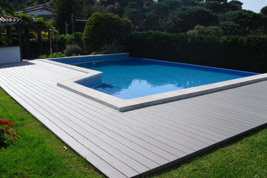 Modelo de casa de la piscina y piscina infinita contemporánea de tamaño medio rectangular en patio trasero
