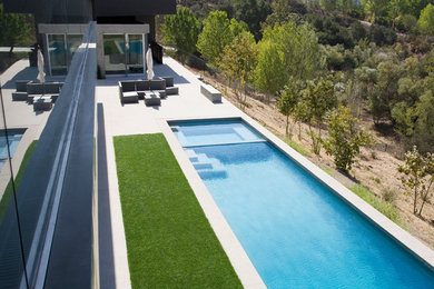 Diseño de piscinas y jacuzzis alargados contemporáneos extra grandes rectangulares en patio delantero con suelo de baldosas