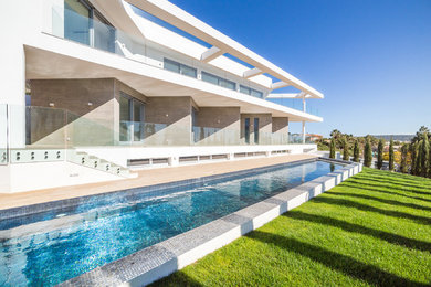 Foto de casa de la piscina y piscina alargada contemporánea grande rectangular en patio delantero
