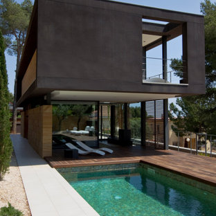 Modelo de piscina actual, de tamaño medio, rectangular, en patio trasero, con suelo de baldosas