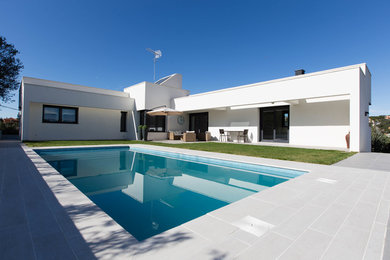 Foto de casa de la piscina y piscina alargada actual de tamaño medio rectangular en patio delantero
