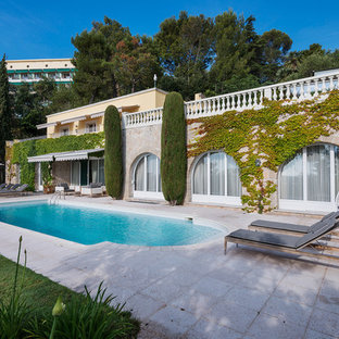 Inspiration pour une très grand piscine arrière méditerranéenne sur mesure avec des pavés en pierre naturelle.
