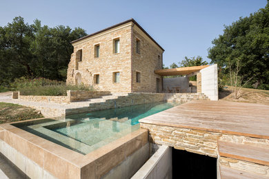 Cette image montre une piscine à débordement et arrière rustique rectangle avec une terrasse en bois.