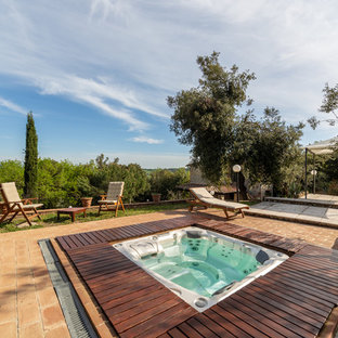 Ispirazione per una piscina country rettangolare dietro casa con una vasca idromassaggio e piastrelle
