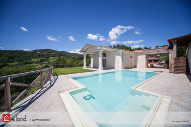 Immagine di una grande piscina a sfioro infinito tradizionale personalizzata davanti casa con una vasca idromassaggio
