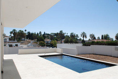 Medium sized modern front rectangular hot tub in Malaga with tiled flooring.