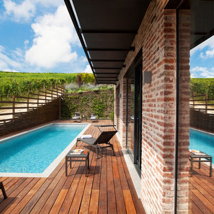 Immagine di una piscina monocorsia country rettangolare dietro casa con pedane