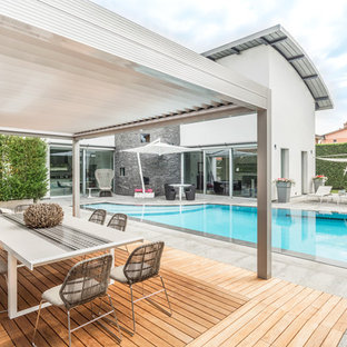 Immagine di una piscina minimal personalizzata dietro casa con pavimentazioni in cemento