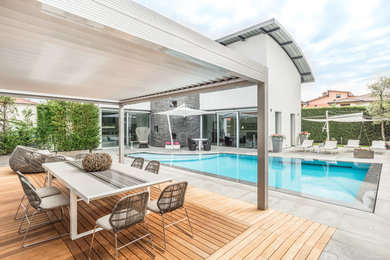 Immagine di una piscina minimal personalizzata dietro casa con pavimentazioni in cemento