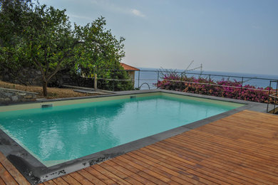 Foto de piscina infinita costera de tamaño medio rectangular en patio con entablado