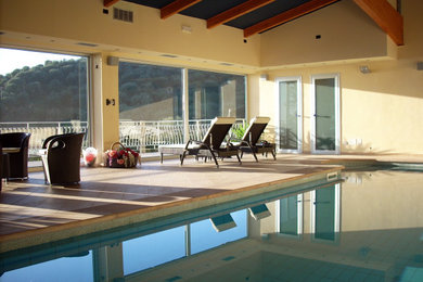 Ispirazione per una piscina coperta a sfioro infinito rettangolare di medie dimensioni con una vasca idromassaggio