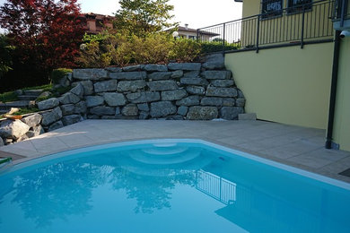 Imagen de piscina mediterránea de tamaño medio a medida en patio lateral con suelo de baldosas