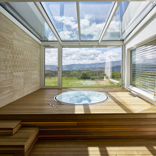 Esempio di una piscina minimal rotonda in cortile con una vasca idromassaggio e pedane