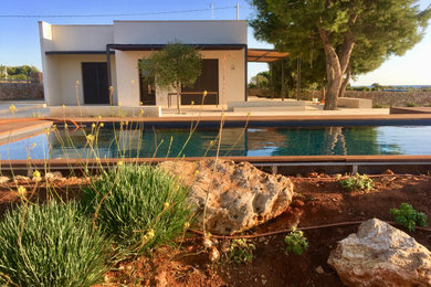 Immagine di una piscina fuori terra mediterranea rettangolare di medie dimensioni e dietro casa con una dépendance a bordo piscina e pavimentazioni in pietra naturale