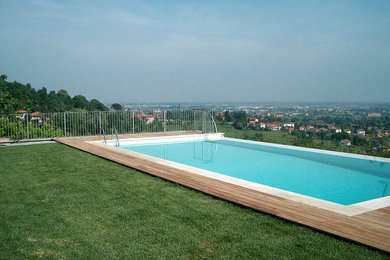 Foto de piscina infinita minimalista grande rectangular en patio delantero con entablado