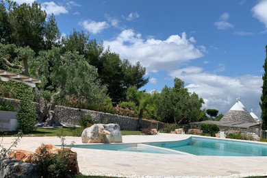 Foto di una piscina mediterranea personalizzata dietro casa con pavimentazioni in pietra naturale