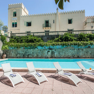 Immagine di una piscina monocorsia mediterranea rettangolare con pavimentazioni in cemento