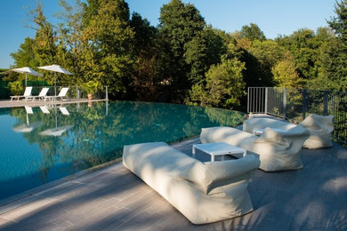 Idee per una piscina a sfioro infinito minimalista personalizzata davanti casa con piastrelle