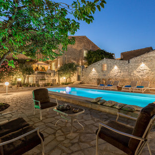 Esempio di una piscina mediterranea rettangolare dietro casa con pavimentazioni in pietra naturale
