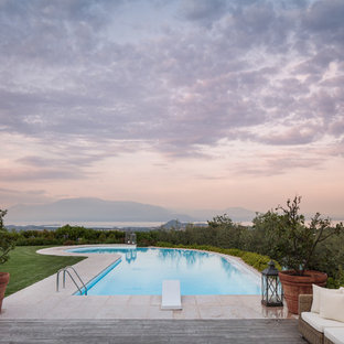 Idee per una piscina monocorsia country personalizzata dietro casa con piastrelle