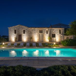 Esempio di una grande piscina monocorsia mediterranea rettangolare dietro casa con pavimentazioni in cemento