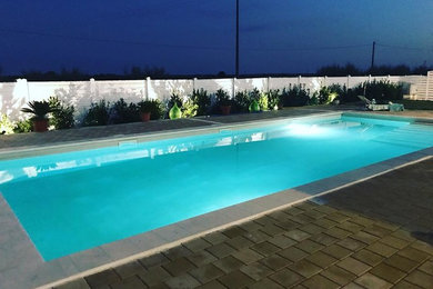 Ispirazione per una grande piscina mediterranea rettangolare dietro casa con pavimentazioni in cemento