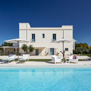 Ispirazione per una grande piscina monocorsia mediterranea rettangolare dietro casa con lastre di cemento