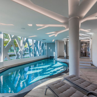 Foto di una piscina coperta design personalizzata con pedane
