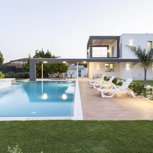 Immagine di una piscina contemporanea rettangolare dietro casa con fontane