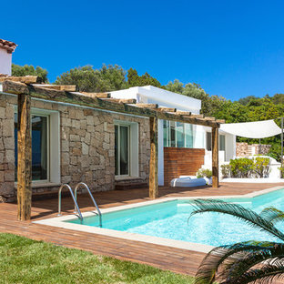 Immagine di una piscina mediterranea di medie dimensioni e dietro casa con pedane