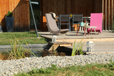 Inspiration pour une piscine naturelle et arrière rustique de taille moyenne et rectangle avec une terrasse en bois.