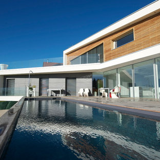 Réalisation d'une très grand piscine arrière design rectangle.