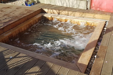 Cette photo montre une piscine scandinave de taille moyenne et sur mesure avec une terrasse en bois.